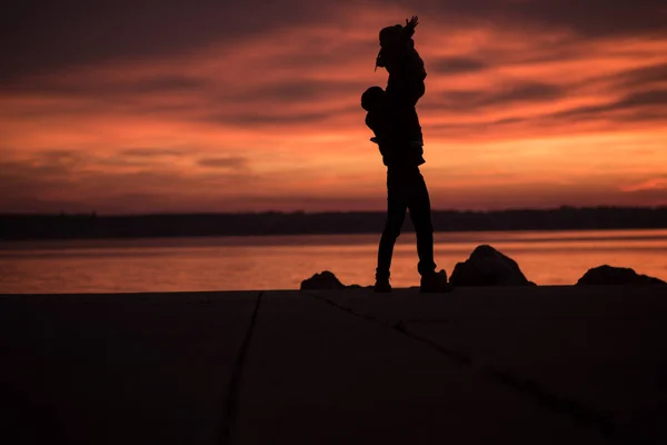 Junger Vater hebt ein kleines Kind in die Luft — Stockfoto