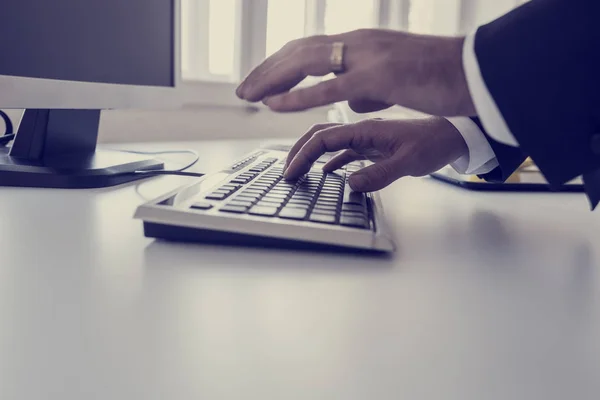 Retro getöntes Bild eines Geschäftsmannes, der auf einer Computertastatur tippt — Stockfoto