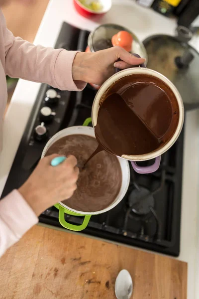 Visão aérea de um cozinheiro esvaziando molho de chocolate de uma panela — Fotografia de Stock