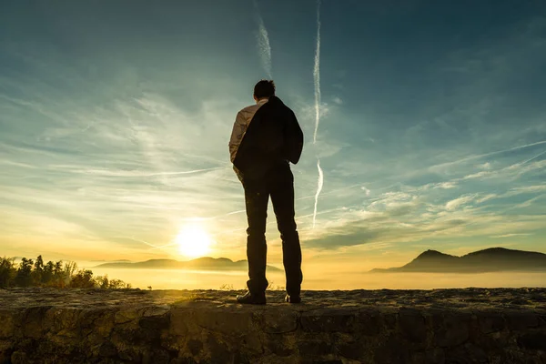 Zakenman in een pak permanent buitenshuis silhouet tegen een co — Stockfoto