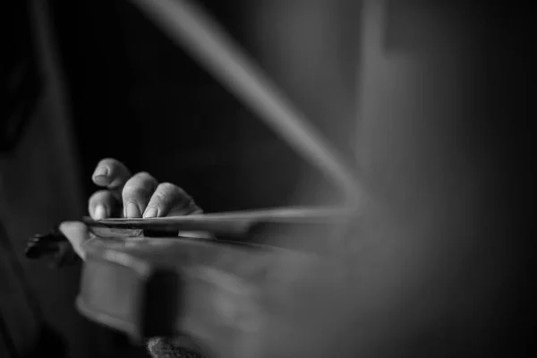 Imagen monocromática de la mano masculina tocando música en violines clásicos —  Fotos de Stock