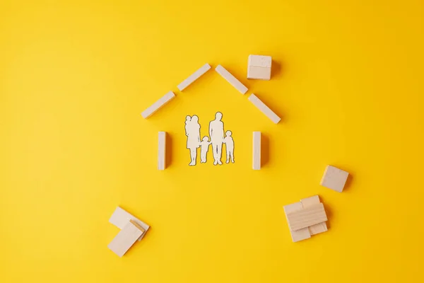 Sílhueta de redução de papel de uma família em casa feita de blocos de madeira — Fotografia de Stock