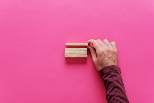 Maschio mano impilamento pioli in legno bianco — Foto Stock