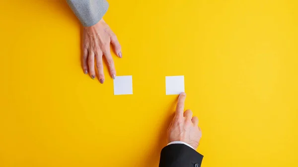 Männliche und weibliche Hand legen jeweils ein leeres weißes Post-it-Papier — Stockfoto