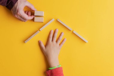 Tahta çivilerden ve bloklardan yapılmış bir evde çocuk eli