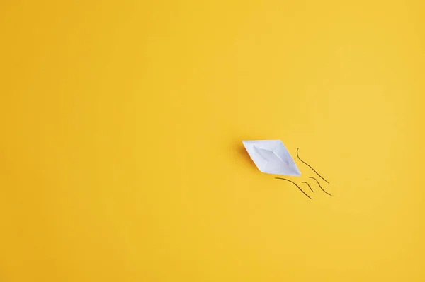 White paper made origami boat on yellow surface — Stock Photo, Image