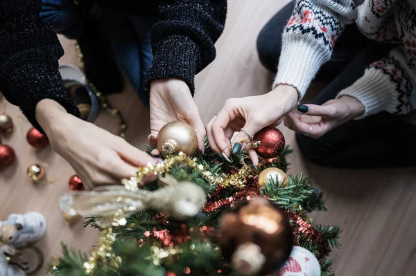 Ansicht von zwei Freundinnen, die gemeinsam den Weihnachtsbaum schmücken — Stockfoto