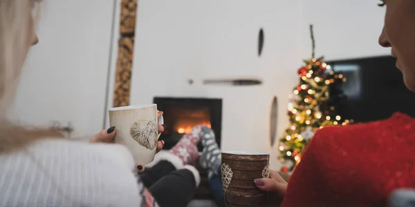 Two girlfriend enjoying by the fireplace at holiday season — Stock Photo, Image