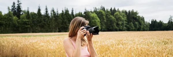 Giovane donna con fotocamera professionale dslr scattare foto al di fuori — Foto Stock