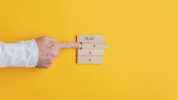 Hand of a businessman choosing a plan A option