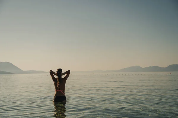 Молода жінка насолоджується ранковим морем — стокове фото