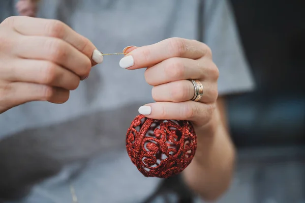 Tying  string to a red Christmas bauble — Stock Photo, Image