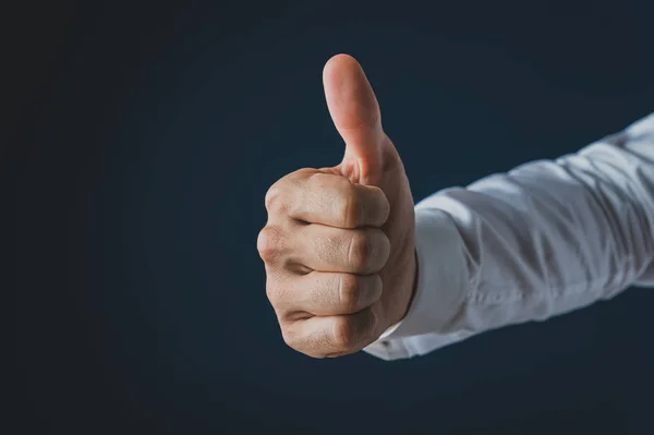Mão de um homem de negócios fazendo um gesto de polegar para cima — Fotografia de Stock