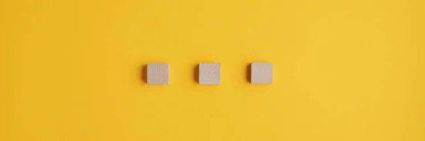 Tres bloques de madera en blanco colocados sobre fondo amarillo — Foto de Stock
