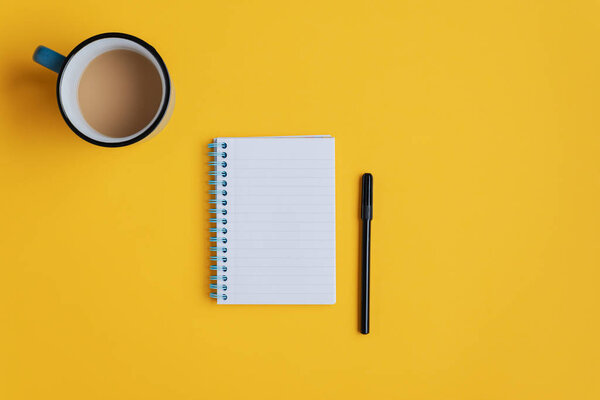 Note pad and marker on yellow background