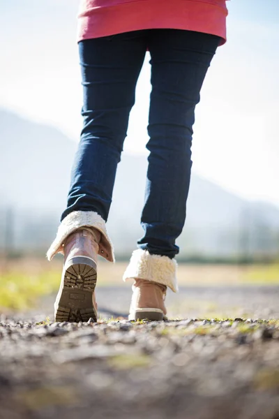 冬のブーツを着た女性が歩道を歩く — ストック写真