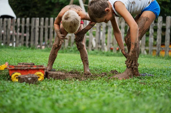 Dua bersaudara bermain dengan lumpur — Stok Foto
