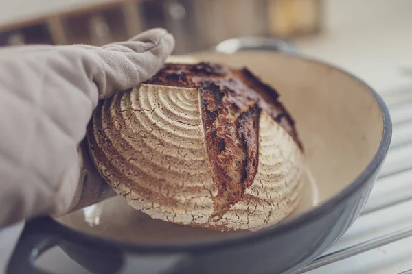 Sacando pan caliente de la olla de barro — Foto de Stock