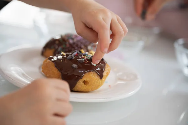 Вид Крупным Планом Ребенка Украшающего Вкусный Домашний Пончик Шоколадным Покрытием — стоковое фото