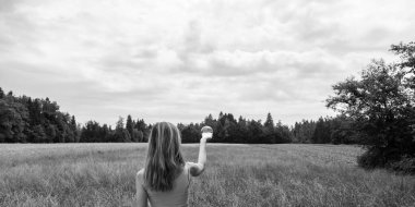 Etrafı tarlalarla çevrili, elinde kristal küreyle güzel bir kadının arkasından bakın..