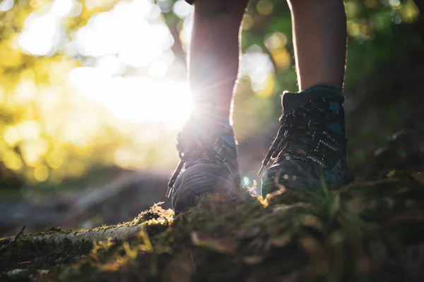 穿着远足靴 站在被灿烂的阳光照亮的山路上的小孩腿的低角度视图 — 图库照片