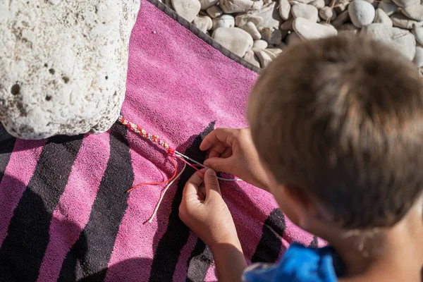 Tampilan Atas Seorang Anak Laki Laki Simpul Gelang String Pantai — Stok Foto
