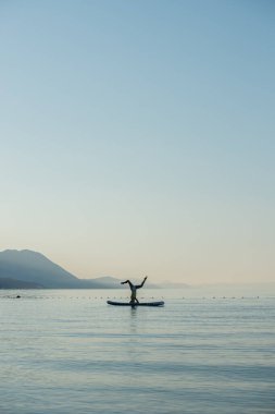 Sağlıklı genç bir kadın, sakin bir sabah denizinde süzülerek yemek masasında başını kaldırıyor..
