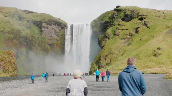 İzlanda 'da şelale ve turistler.