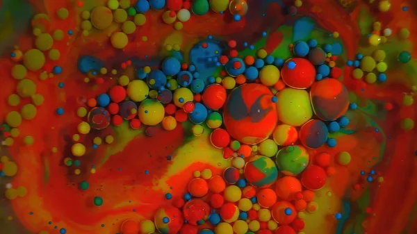 Multi-colored bubbles in the water. Abstract rainbow drops, can be used as background. Vividly beautiful this image is an abstract macro depiction. Still life cosmetics photography. Overhead top down. yellow