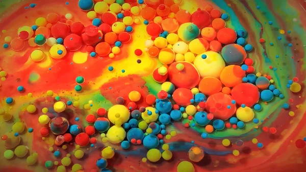 Multi-colored bubbles in the water. Abstract rainbow drops, can be used as background. Vividly beautiful this image is an abstract macro depiction. Still life cosmetics photography. Overhead top down. Slow