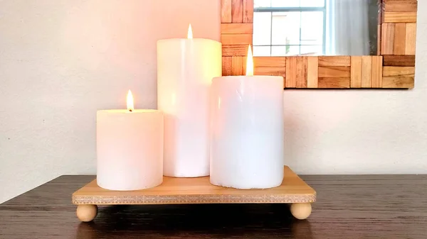 Candles on a stand. Three candles on a decorative stand near the mirror.