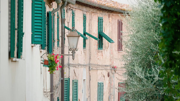 Tuscany, Italy. Windows and a lantern on the old walls of houses.