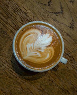 Rosette latte sanat eseri, latte, ahşap masada.