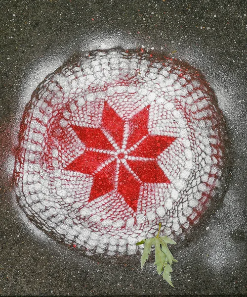 用红白相间的喷雾喷在路面砖上的花边图案 — 图库照片
