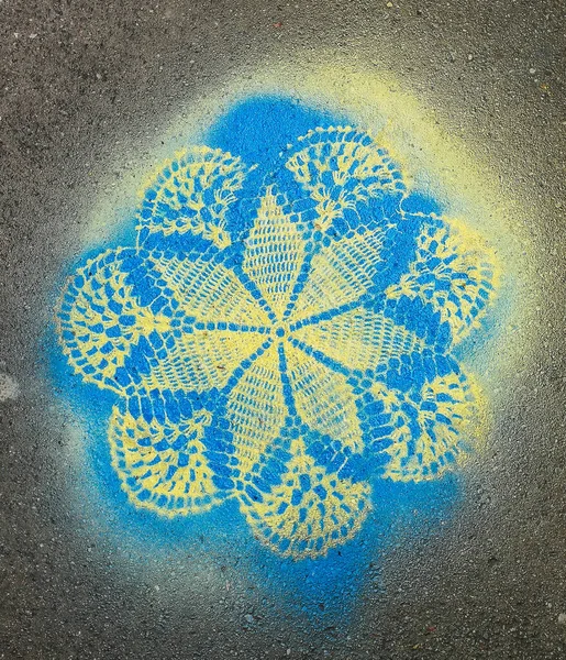 用蓝色和黄色喷雾喷涂在路面砖上的花边图案 — 图库照片