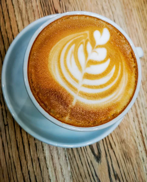 Tulip latte art on cafe latte on wooden table