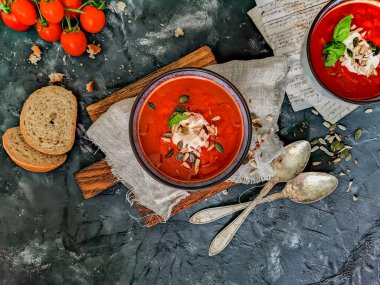 Kağıt banknotlar, ekmek, eski kaşıklar ve kiraz domatesli düz domates çorbası.