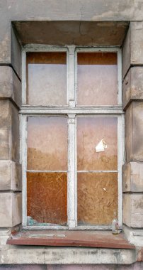 Wroclaw şehrindeki eski bir apartmanın eski ahşap penceresinde kırık camlar.