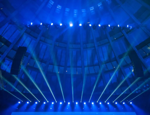 Lookup to ceiling in conference hall with blue lights over screen