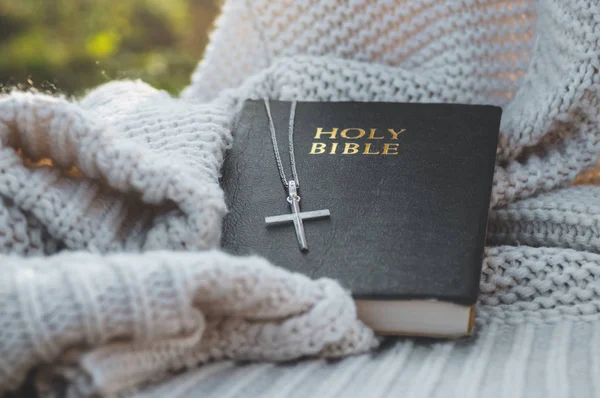 A Bíblia e a cruz jazem em uma camisola quente. Conceito de fé, espiritualidade — Fotografia de Stock