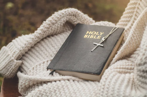 Alkitab dan salib terletak pada sweater hangat. Konsep untuk iman, spiritualitas — Stok Foto