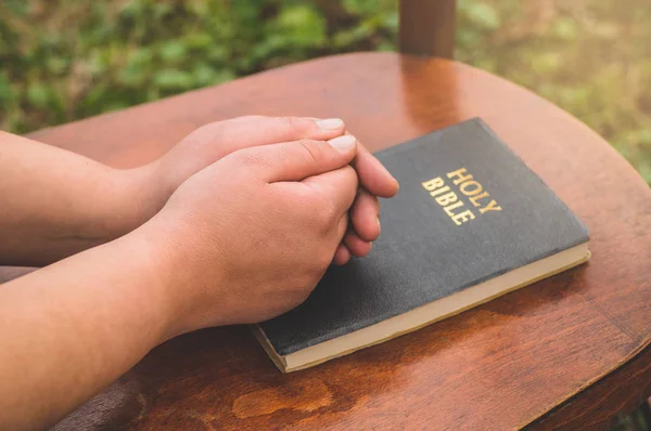 Wanita berdoa di latar belakang Alkitab. Tangan dilipat dalam konsep doa untuk iman, spiritualitas dan agama . — Stok Foto
