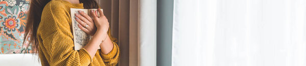 Привлекательная молодая женщина читает книгу дома. Задумчивая девушка читает важную книгу
