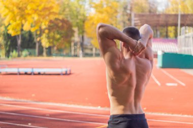 Şehir stadyumunda kaslı ve zayıf vücutlu bir erkek model.. 