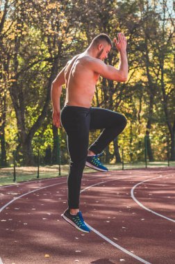 Şehir stadyumunda kaslı ve zayıf vücutlu bir erkek model.. 