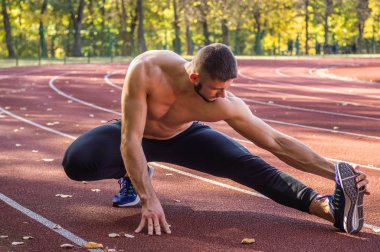 Şehir stadyumunda kaslı ve zayıf vücutlu bir erkek model.. 