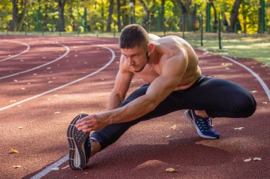 Şehir stadyumunda kaslı ve zayıf vücutlu bir erkek model.. 