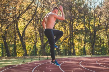 Şehir stadyumunda kaslı ve zayıf vücutlu bir erkek model.. 