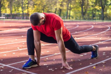 Şehir stadyumunda kaslı ve zayıf vücutlu bir erkek model.. 