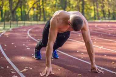 Şehir stadyumunda kaslı ve zayıf vücutlu bir erkek model.. 